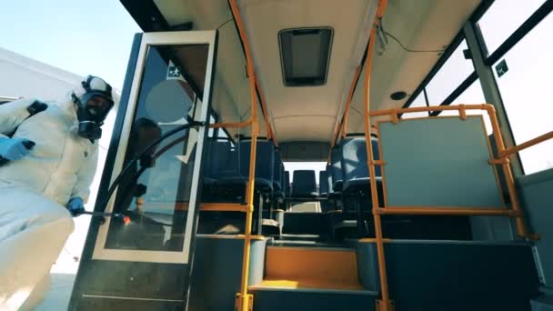 Prevención del Coronavirus, concepto epidémico. Vista interior de un autobús siendo rociado con productos químicos de desinfección — Vídeos de Stock