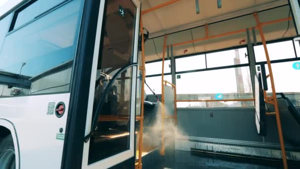 Het interieur van een bus wordt chemisch ontsmet door een inspecteur. Coronaviruspreventie, epidemisch concept. — Stockvideo