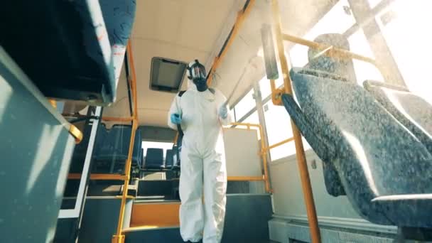 A busz belsejét vegyi anyagokkal permetezi a fertőtlenítő. Coronavirus prevenció, járványügyi koncepció. — Stock videók