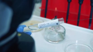 Laboratuvar çalışanı tüpü sıvıyla dolduruyor. Coronavirus, COVID-19, 2019-ncov ilaç araştırma konsepti.