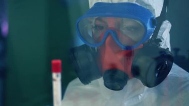 Araştırmacı covid-19 aşısı olan bir tüpe bakıyor. Coronavirus, COVID-19, 2019-ncov ilaç araştırma konsepti.