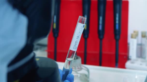 Científico llena tubo de vidrio con líquido mientras trabaja con coronavirus . — Vídeos de Stock