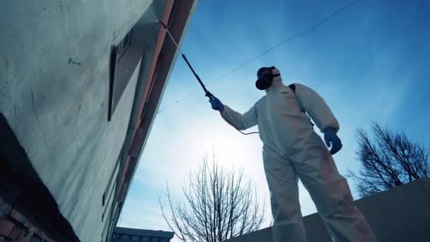 Védőruhás munkás fertőtlenít egy épületet.. — Stock videók