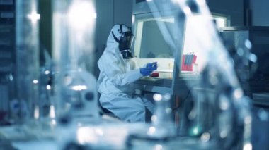 Araştırmacı laboratuvarda çalışırken tüpü sıvıyla kontrol ediyor..