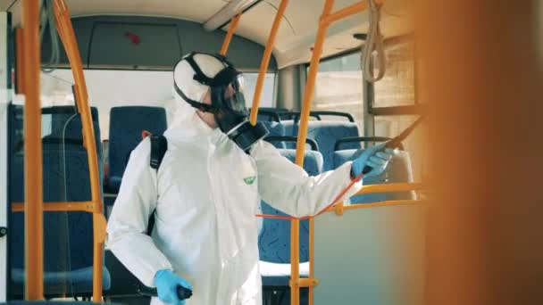 Desinfector spuit chemische stof op de ramen van de bus — Stockvideo