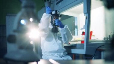 Laboratuvar çalışanı aşı geliştirirken tüpü kontrol ediyor. Coronavirus, COVID-19, 2019-ncov ilaç araştırma konsepti.