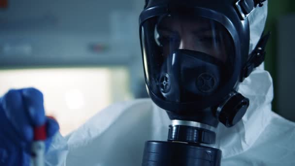 Person in hazmat holds a tube with coronavirus result. — Stock Video