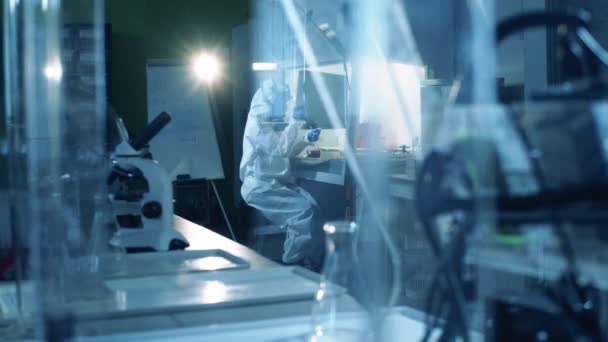 Viroloog in hazmat werkt in het laboratorium tijdens het maken van het vaccin. Coronavirus, COVID-19, 2019-ncov onderzoek naar geneesmiddelen. — Stockvideo
