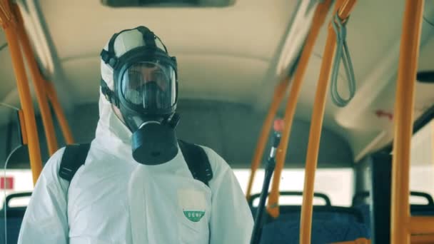 Otobüs dezenfeksiyonu sırasında tehlikeli madde giysisi giymiş sağlık müfettişi. — Stok video