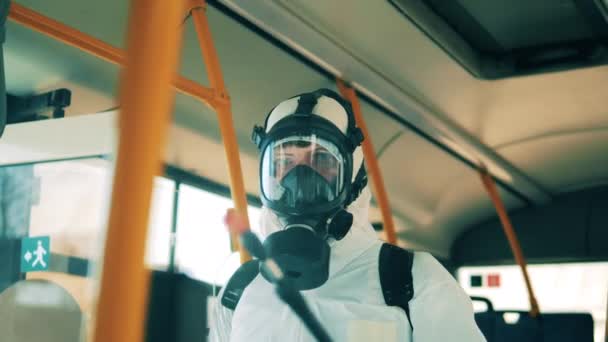 Especialista em desinfecção num fato de protecção durante a descontaminação dos autocarros — Vídeo de Stock