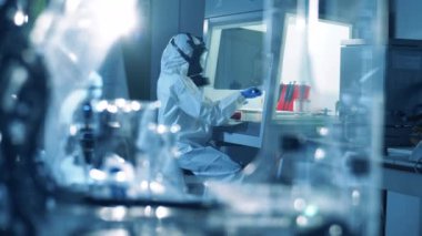 Bir işçi aşı geliştirirken laboratuvar aygıtı kullanır. Coronavirus, COVID-19, 2019-ncov ilaç araştırma konsepti.