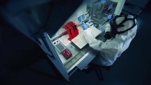有一个穿防护服的人在实验室里与头孢病毒一起工作. — 图库视频影像
