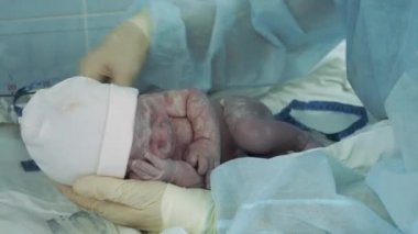 Doktor yeni doğmuş bir bebeği ölçüyor.
