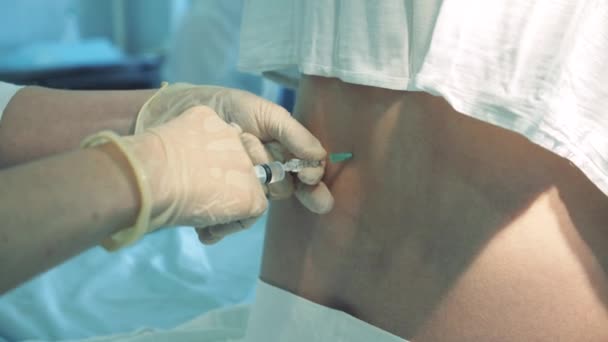 Doktor bir kadın hastayı sırtına enjekte ediyor. — Stok video