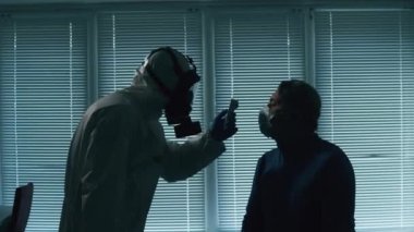 Erkek hasta ateşini bir doktor ölçüyor.