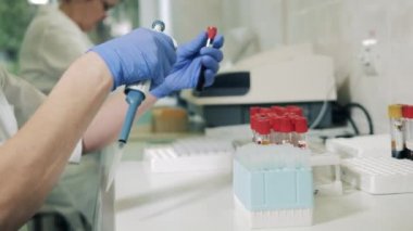 İnsanlar laboratuarda plastik tüplerle çalışıyorlar..