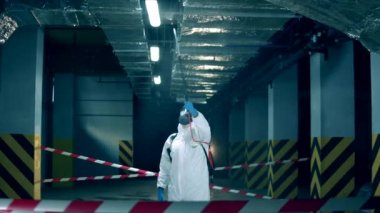 Erkek işçi covid-19 salgını sırasında antiseptik sıkar..