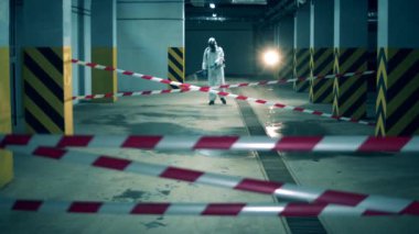 Koruyucu giysili bir adam odayı sterilize ediyor. Coronavirus önleme, covid-19 koruyucu dezenfeksiyon.