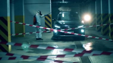 Adam arabayı spreyle dezenfekte ediyor..