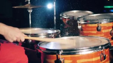 Bir adam davul çalarken sopa kullanıyor. Davulcu, davulcu, davullar ağır çekimde