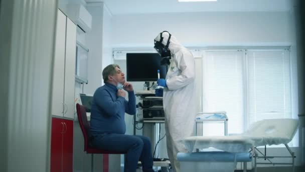 COVID 19, virüs, koronavirüs, salgın konsepti. Hastane çalışanı yaşlı bir hastanın ağzından örnek alıyor. — Stok video