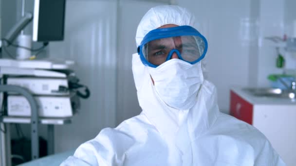 Dokter in een hazmat pak heeft een thermometer met koorts. — Stockvideo