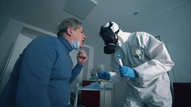 Старший мужчина делает мазок для рта в больничной палате. COVID-19, вирус, коронавирус, концепция эпидемии . — стоковое видео