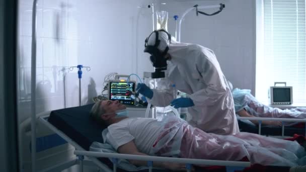 COVID 19, virus, koronavirus, epidemie. Záchranář v ochranném obleku bere výtěr z nosu staršímu pacientovi. — Stock video