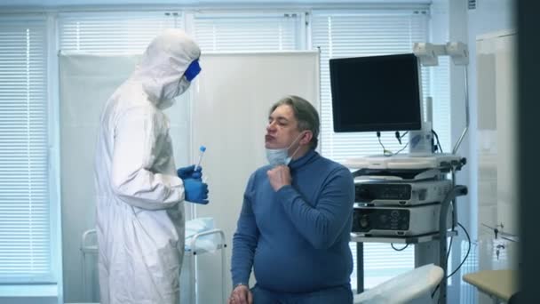 Uma amostra biológica está a ser colhida de um paciente por um paramédico. COVID 19, vírus, coronavírus, conceito de epidemia . — Vídeo de Stock