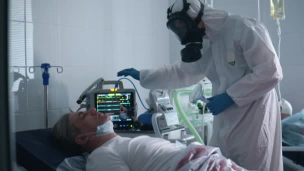 Медицинский работник устанавливает респираторное устройство на пациента — стоковое видео
