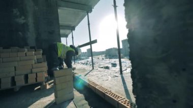 İşçiler, devam etmekte olan bir binanın duvarcılığını yapıyorlar.