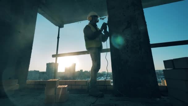 Le constructeur mâle polit une colonne de ciment. Travailleur de la construction sur un chantier . — Video