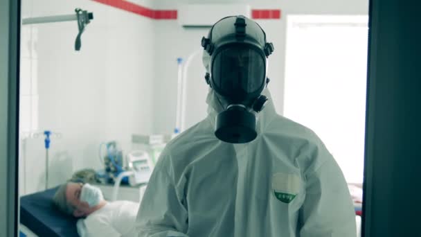 Blijf thuis. Een dokter in Hazmat houdt een laken vast om mensen aan te sporen thuis te blijven.. — Stockvideo