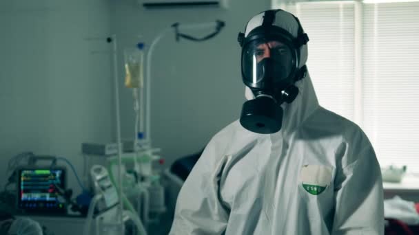 Een persoon in beschermend pak vrolijkt mensen op tijdens een pandemie.. — Stockvideo