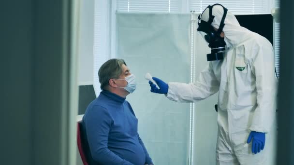 Медицинский тест на коронавирусную диагностику в больнице. Медицинский работник проверяет температуру мужчин в больнице . — стоковое видео