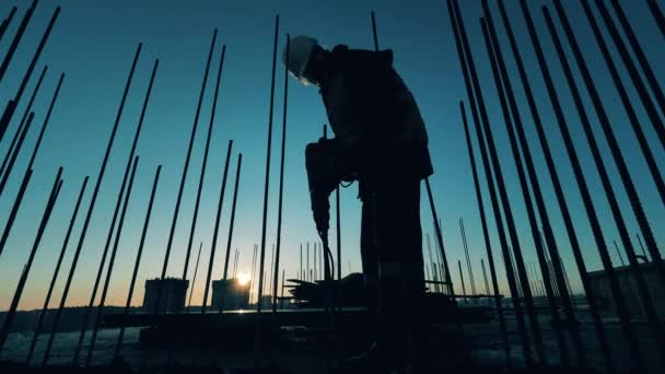 Construtor masculino está usando um martelo pneumático para quebrar concreto — Vídeo de Stock