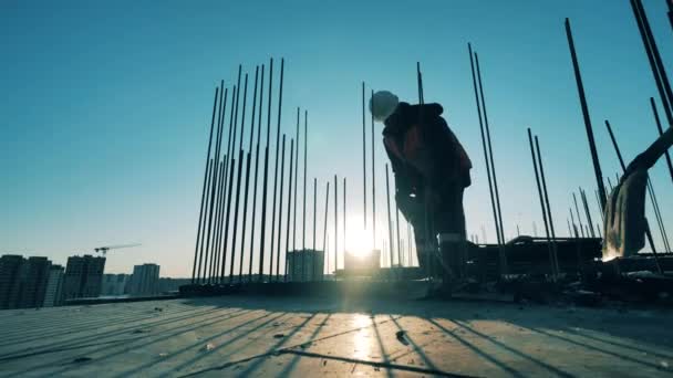 Az építőmunkás betöri a betont egy légkalapáccsal. Építési munkás egy építkezésen. — Stock videók