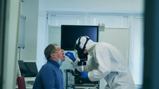 En läkare tar en patientservett för coronavirus test. — Stockvideo