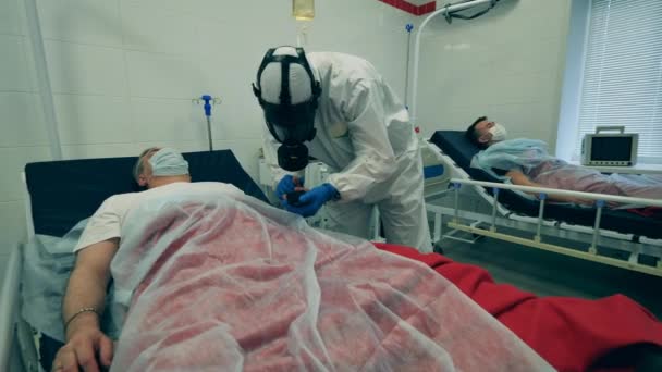 Working doctor treats a patient with ventilator during coronavirus pandemic. Coronavirus, covid-19 patient in intensive care unit at a hospital. — Stock Video