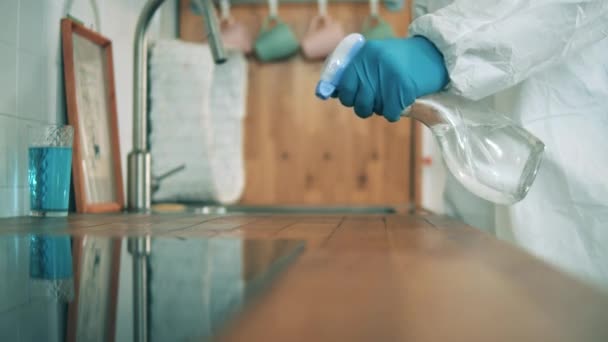 Table surface is getting sanitized by a person in a hazmat suit — Stock Video