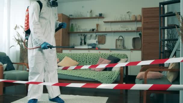 हॅझमॅट सूटमध्ये निर्जंतुकीकरण फ्लॅट स्वच्छ करीत आहे — स्टॉक व्हिडिओ