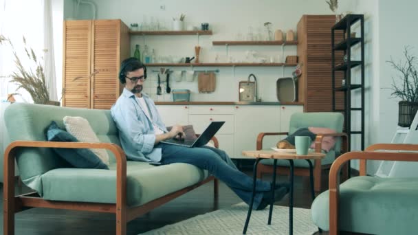 A man is browsing gadgets on self-isolation at home during pandemic of Coronavirus, covid-19 outbreak. — Stock Video