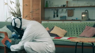 Temizlik uzmanı odada mobilyaları dezenfekte ediyor.