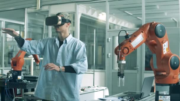 Inżynier w okularach VR manipuluje urządzeniem bionicznym. Uczniowie liceum studiujący robotykę w laboratorium uniwersyteckim. — Wideo stockowe