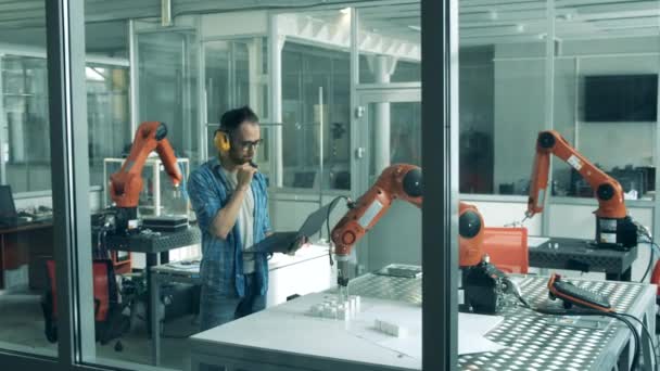 Vetenskapslabb med en rörlig robotarm observeras av en forskare — Stockvideo