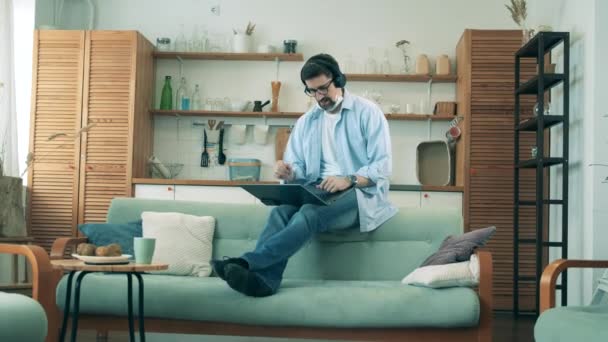 Sala de estar com um homem fazendo uma videocall enquanto se auto-isola durante a pandemia de Coronavirus, covid-19 . — Vídeo de Stock