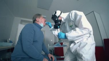 Bir doktor Coronavirus salgını sırasında hastaya koronavirüs testi uygular. Coronavirus, hastahanedeki test sırasında kovid 19 enfekte olmuş hasta..