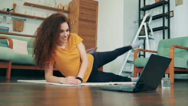 Uma mulher está sorrindo enquanto se exercita em casa — Vídeo de Stock