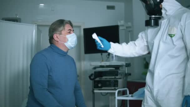 Travailleur médical dans Hazmat mesure la température des patients . — Video