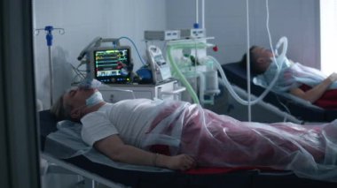 Koronavirüsü olan erkekler tıbbi aletlerle tedavi görüyorlar..